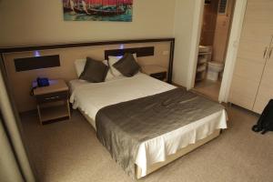 - une chambre avec un grand lit et une tête de lit en bois dans l'établissement Vita Park Boutique Hotel, à Konak