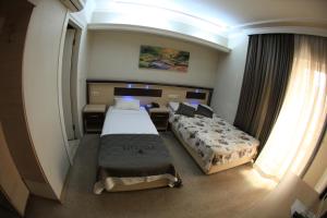 a hotel room with two beds and a window at Vita Park Boutique Hotel in Konak