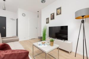 a living room with a couch and a table at Stacja Wola Apartment Gumińska by Renters in Warsaw