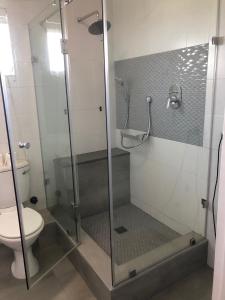 a bathroom with a glass shower with a toilet at Whale Rock Estate Hermanus sea view apartment in Hermanus