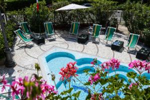 eine Gruppe von Stühlen und ein Pool mit Blumen in der Unterkunft Esedra Hotel in Rimini