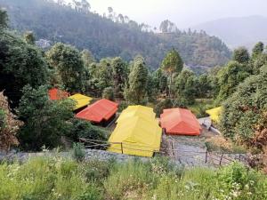 a group of colorful tents in a field at Kausani adventures & camping in Kausani