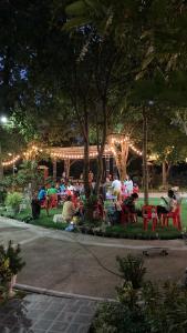 un grupo de personas sentadas en un parque por la noche en Keith Ratchaburi, en Ratchaburi