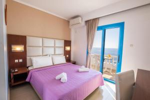 a bedroom with a purple bed and a balcony at Castelia Bay Hotel in Amoopi