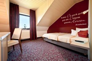 una camera con letto, scrivania e finestra di Hotel Bei den Tongruben a Ravolzhausen