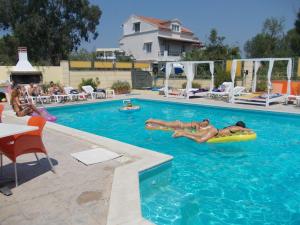 a group of people laying in a swimming pool at Kavos Central Gardens in Kavos