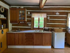 a kitchen with wooden cabinets and a white refrigerator at Roubenka Dolní Rokytnice in Rokytnice nad Jizerou