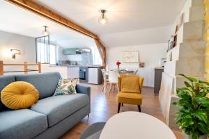 ein Wohnzimmer mit einem blauen Sofa und einer Küche in der Unterkunft Le Clos Eugenie - Charmante maison avec jardin et vue sur la Loire in Gennes