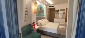 um pequeno quarto com uma cama e uma cadeira verde em Ilianthos Apartments & Rooms em Mikros Gialos