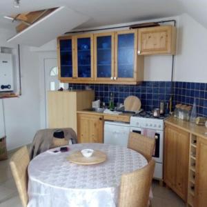 a kitchen with a table and chairs and a table and a kitchen with a table at Szentmihályi apartman in Balatonboglár