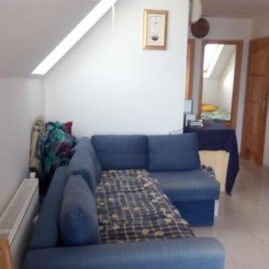 eine blaue Couch im Wohnzimmer in der Unterkunft Szentmihályi apartman in Balatonboglár