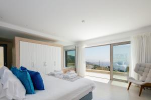 een slaapkamer met een groot bed en een groot raam bij Melampes Villa in Mélambes