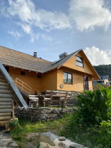 a large wooden house with a porch at Zlatna koliba Namir Zuka in Fojnica