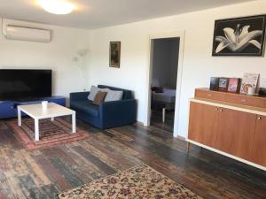 a living room with a blue couch and a table at Alaçatı Merkezde Otel konforu A iki odalı in Alacati