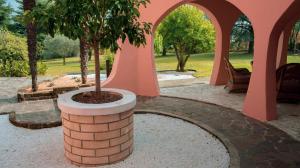 a brick pillar with a tree in a courtyard at Albha - Villa Esotica in Monteviale