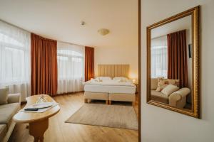 a hotel room with a bed and a mirror at Penzión Kráľov Prameň in Spišská Nová Ves