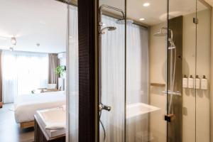 ein Badezimmer mit Dusche und Waschbecken und ein Bett in der Unterkunft Van Heeckeren Hotel in Nes + 37 Fotos