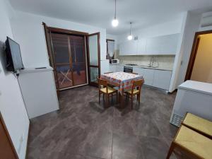 a kitchen with a table and chairs and a refrigerator at La Maddalenetta Casa Vacanze in Alghero