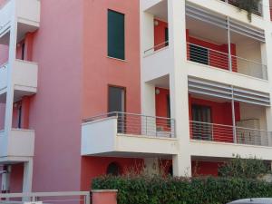 an apartment building with pink and white at La Maddalenetta Casa Vacanze in Alghero