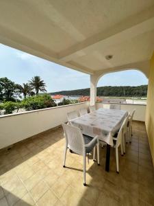 a dining room with a table and chairs on a balcony at Haus Zdenka in Rab