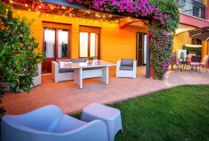 eine Terrasse mit Tisch und Stühlen und Blumen in der Unterkunft Pura Villa- Buganvillas Ayamonte in Ayamonte