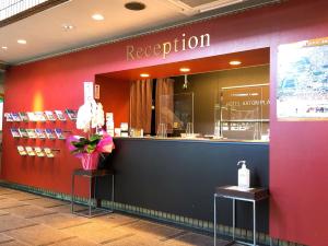 a restaurant with a red wall and a counter at Hotel Aston Hotel Osaka Sakai in Sakai