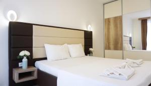 a bedroom with a white bed with a large mirror at Ponte Apartments in Ulcinj