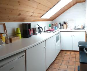 eine Küche mit einer weißen Arbeitsplatte in einem Zimmer in der Unterkunft 2-Zimmer DG-Apartment mit eigener Sauna in Oberhaching