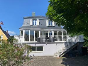 a large white house with a porch and a balcony at Magnifique villa à 5 minutes de Colmar in Horbourg