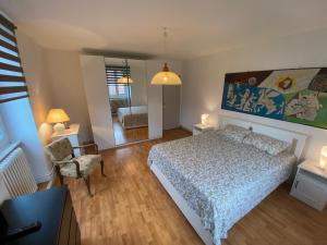 1 dormitorio con cama, silla y espejo en Magnifique villa à 5 minutes de Colmar, en Horbourg