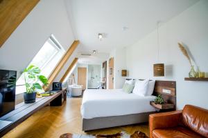 ein Schlafzimmer mit einem Bett und einer Couch in der Unterkunft Van Heeckeren Hotel in Nes