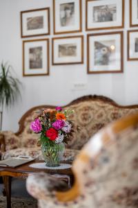 un jarrón de flores sentado en una mesa con un sofá en Hotel Kotnik Superior - Small & Beautiful, en Kranjska Gora