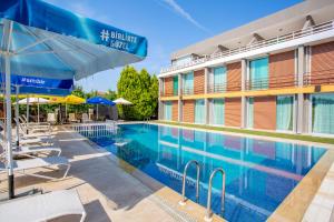 einen Pool in einem Hotel mit Stühlen und Sonnenschirmen in der Unterkunft Zeytin Bahcesi Hotel in İznik