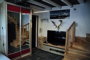 uma sala de estar com uma televisão de ecrã plano e escadas em Domki u Biesiady em Lesko