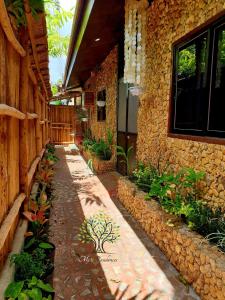 ein Steingebäude mit einem Gehweg mit Pflanzen darauf in der Unterkunft MJ's Residences Garden Hotel and Kids Indoor Playhouse in Moalboal