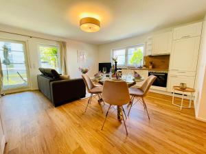 a living room with a table and a couch at Ferien-Apartment Silberweide - mit priv Strandzugang in Friedrichshafen