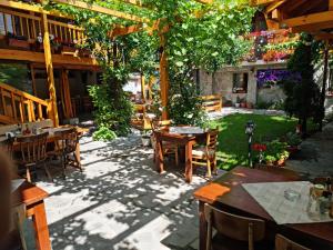 een terras met tafels en stoelen in een restaurant bij Mamin Kolio in Bansko