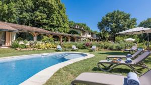 una piscina con sillas y una sombrilla junto a una casa en Villa Mimmina 8, Emma Villas, en Civitella in Val di Chiana