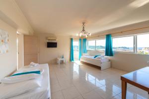 a large room with two beds and a table at The Senses Tsilivi Hotel in Plános