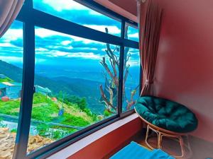a window with a green chair and a view of the ocean at Sun Villa Tam Đảo in Vĩnh Phúc