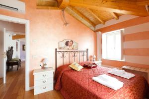 a bedroom with a bed with a red bedspread at Barchi Resort - Apartments & Suites in San Felice del Benaco