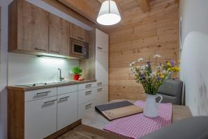 eine kleine Küche mit einem Tisch und einer Vase aus Blumen in der Unterkunft Ferienwohnung Klancnik in Bad Eisenkappel