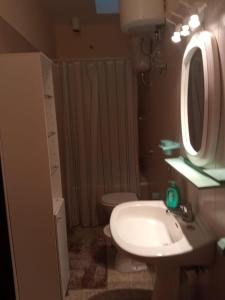een badkamer met een wastafel, een toilet en een spiegel bij Villetta indipendente in villaggio a 2 passi dal mare in Santa Maria al Bagno