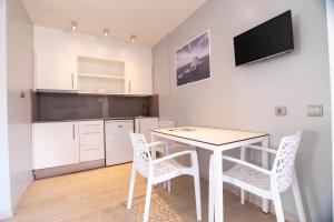 a kitchen and dining room with a table and chairs at Apartamentos Bora Bora - Adults Only in Playa d'en Bossa