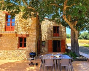 a table and chairs in front of a stone building at Recientemente restaurada ideal para grupos in Cabanellas