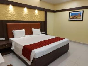 a bedroom with a large bed in a room at sri balaji grand hotel in Kumbakonam