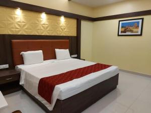 1 dormitorio con 1 cama grande en una habitación en sri balaji grand hotel, en Kumbakonam