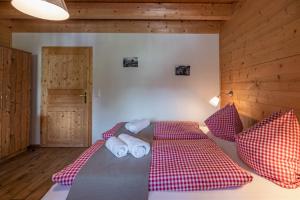 Schlafzimmer mit einem Bett mit roter und weißer Bettwäsche und Kissen in der Unterkunft Ferienwohnung Klancnik in Bad Eisenkappel