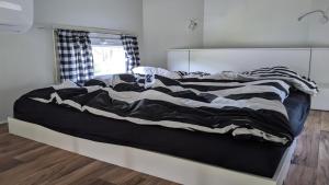 a bed with a black and white comforter in a bedroom at Außergewöhnlich übernachten bei Tübingen. in Ammerbuch