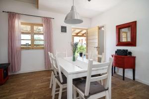 una sala da pranzo bianca con tavolo e sedie bianchi di Country House Frane near Krka Waterfalls & Šibenik a Lađevci